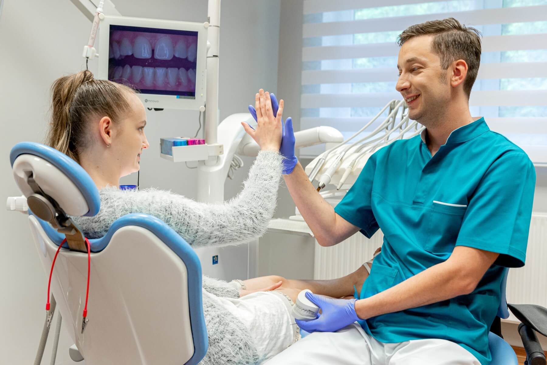 Dentysta opiekujący się młodą pacjentką w gabinecie stomatologicznym dla dzieci