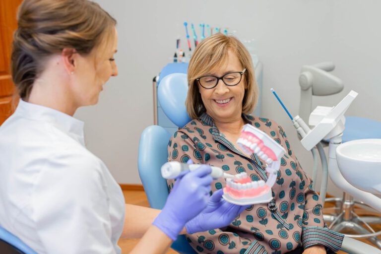 Dentystka wyjaśniająca proces leczenia stomatologicznego pacjentce