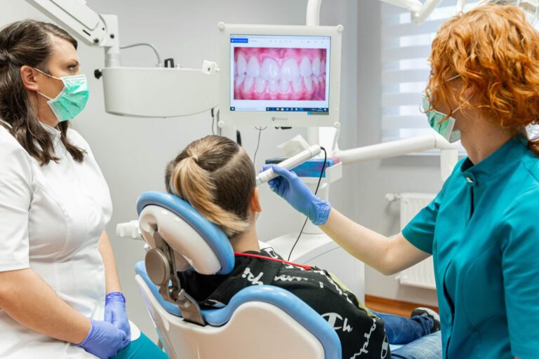 Dentystka wykonująca zdjęcie zębów przed procesem leczenia stomatologicznego