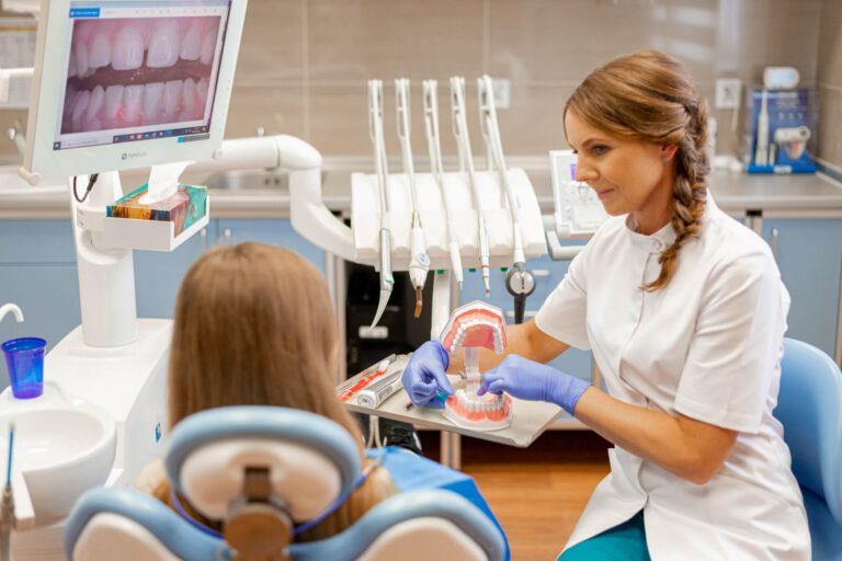 Dentystka wyjaśniająca młodej pacjentce dalsze leczenie
